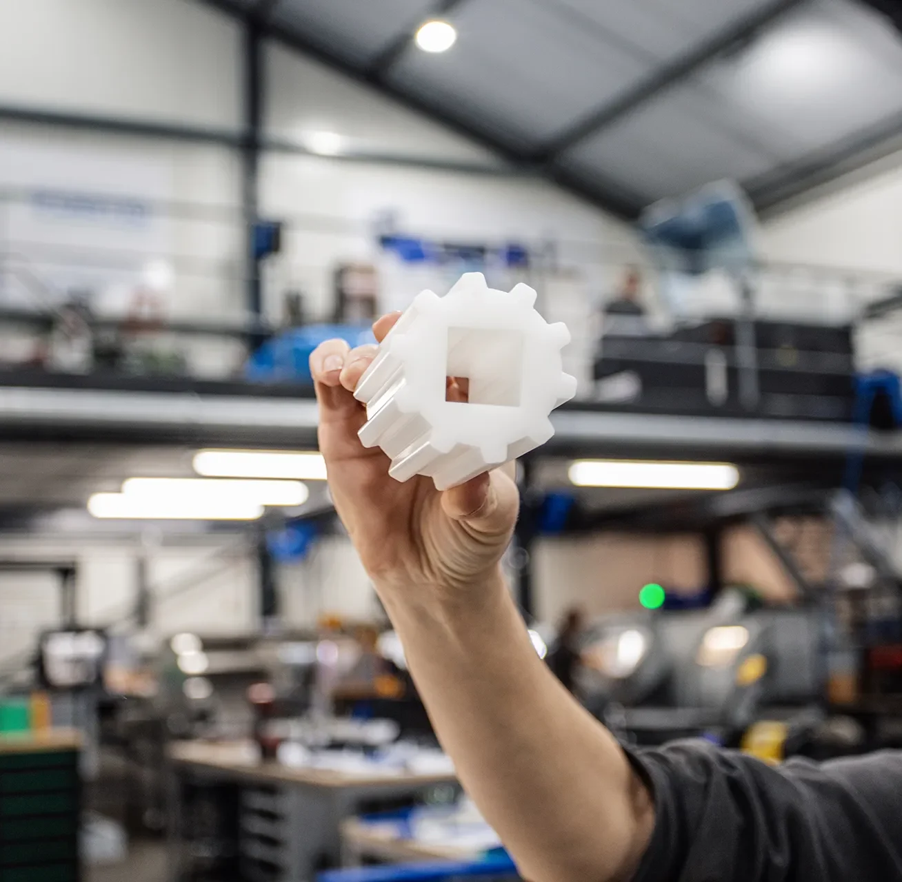 Medewerker toont custom plastic onderdeel uit de voedselverwerking