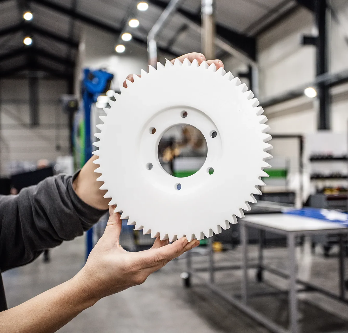 Medewerker toont custom plastic onderdeel uit de voedselverwerking