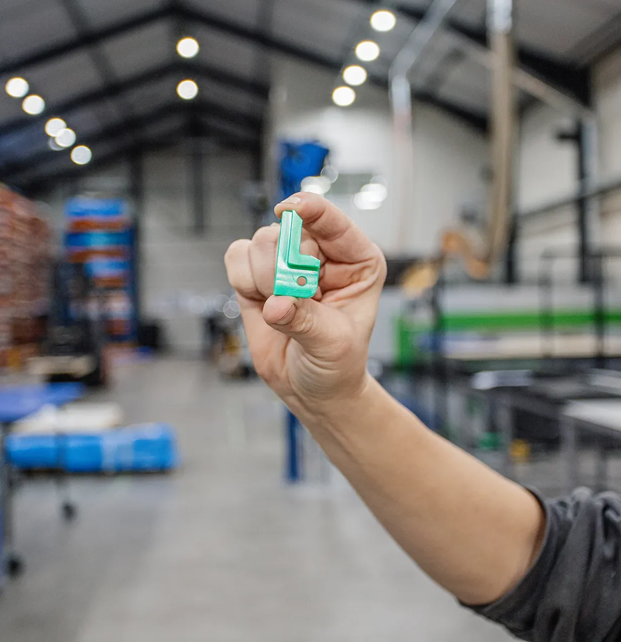 Medewerker toont custom plastic onderdeel uit de voedselverwerking