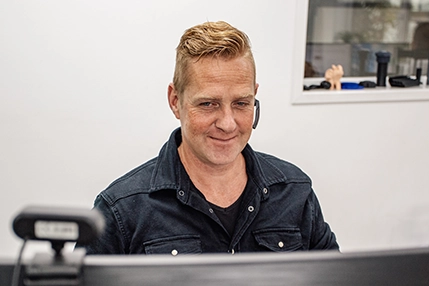 medewerker van profplastic bellend achter zijn computer